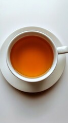 Freshly brewed tea in a white cup sits elegantly on a simple saucer, showcasing its warm amber hue against a minimalist backdrop, perfect for calming moments.