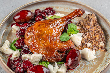 Roasted duck leg served with cherry sauce, soft cheese, and seed crispbread.