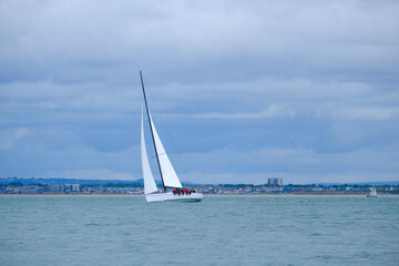 Obraz premium Sailing boats and yachts racing in the Isle of Wight, Round the Island Race 2025, in stormy and rainy conditions