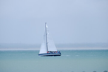 Fototapeta premium Sailing boats and yachts racing in the Isle of Wight, Round the Island Race 2025, in stormy and rainy conditions