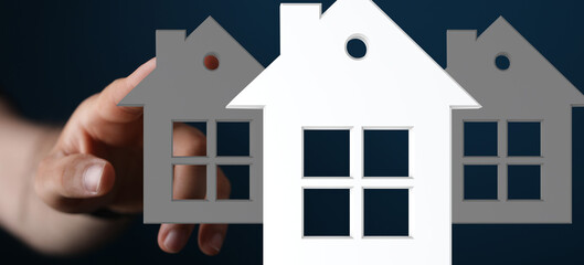 Image of a hand choosing between house models. Ideal for real estate, property, and home concepts.
