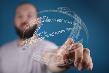 A man interacts with a digital sphere showing lines of code, representing internet technology and...