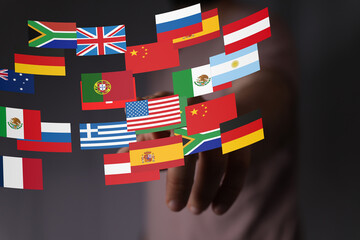 Image of a hand interacting with various country flags, representing global business and...