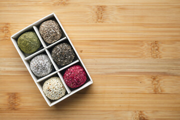 Vegan raw sweet balls on a wooden background. Sugar-free and gluten-free sweets.