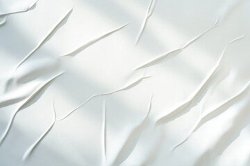 Soft white paper with delicate folds and light shadows creates a minimal, textured background