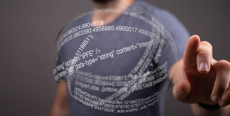 Close-up of a person's hand interacting with a digital hologram displaying lines of code.