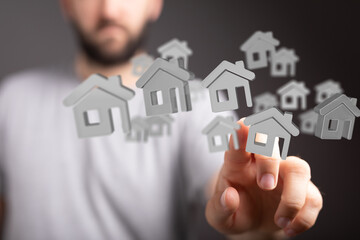 Person chooses a digital home, symbolizing property selection and real estate investment.