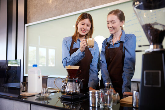 young barista woman making fresh coffee from machine and checking quality in the cafe