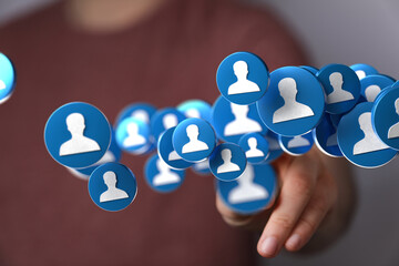 Image of hand interacting with digital profile icons, symbolizing social media reach and networking.