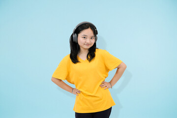young asian woman excitedly gesture hands on hips in studio blue background
