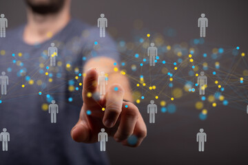 Hand interacts with a network of digital people, symbolizing global connections and communication.