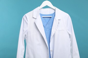 Doctor's coat on hanger against blue background