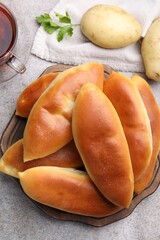 Tasty baked patties and ingredients on grey textured table, flat lay