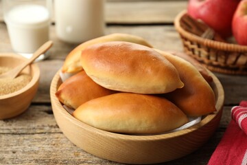 Tasty baked patties and ingredients on wooden table, closeup
