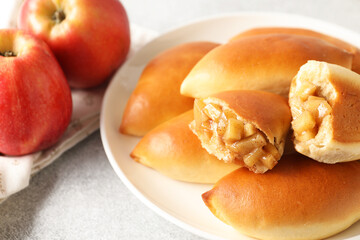Tasty baked patties with apples on light grey table, closeup