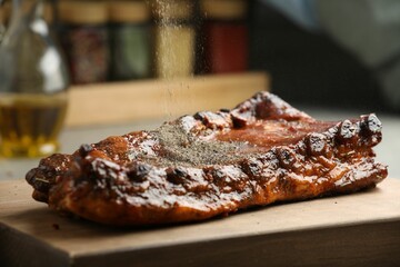 Adding spices to tasty dish at table, closeup