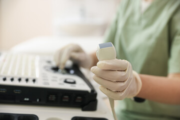 Professional sonographer with ultrasound machine in clinic, closeup