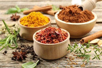Different aromatic spices on wooden table, closeup