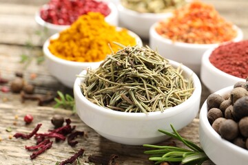 Different aromatic spices on wooden table, closeup