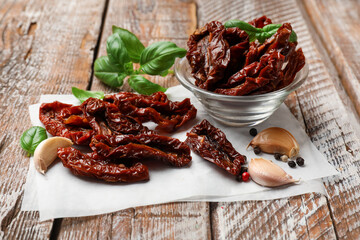 Delicious sun dried tomatoes and spices on wooden table, closeup