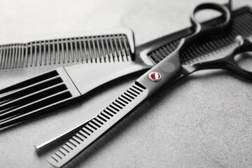 Different hairdresser's tools on grey table, closeup