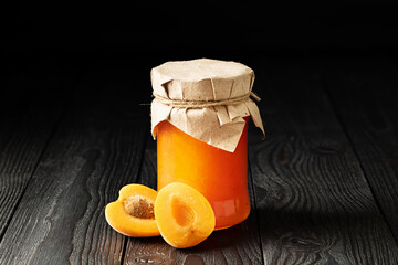 Jar of Peach Jam with Fresh Sliced Peach on Wooden Background