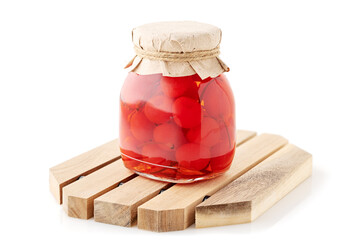 Jar of Preserved Cherries with Craft Paper Lid on Wooden Stand, Isolated on White