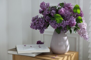 Bouquet of beautiful lilac flowers and books on wooden table