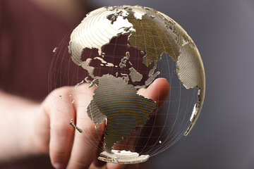 High-quality stock photo of a hand interacting with a transparent 3D globe, representing global...