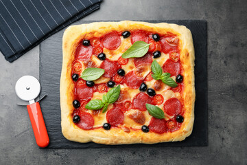 Tasty homemade pizza and cutter on grey table, top view