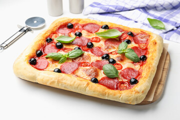 Tasty homemade pizza and cutter on white table, closeup