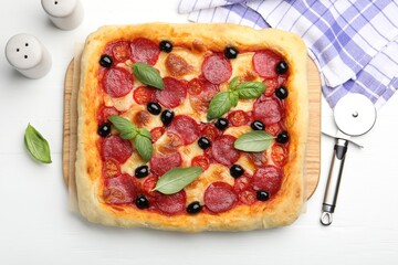 Tasty homemade pizza and cutter on white table, flat lay