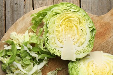 Cut cabbages on wooden table, flat lay