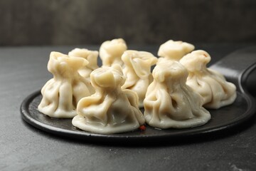 Delicious khinkali with spices on black table, closeup