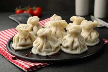 Delicious khinkali served on black table, closeup