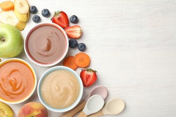 Baby food. Tasty puree in bowls and different ingredients on white wooden table, flat lay. Space...