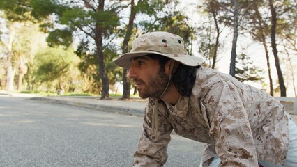 Fototapeta premium Soldier Crawls On The Ground And Smiling Approaches A Cat To Save It