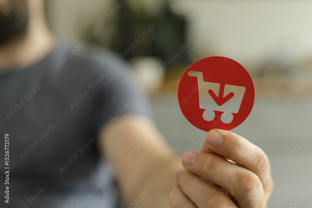 Poster close-up of a person holding a red circle with a shopping cart icon, symbolizing online purchases an