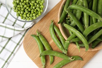 Fresh ripe green peas on white wooden table, flat lay