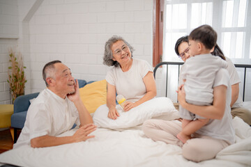 Obraz premium Family gathering in a cozy bedroom with grandparents, parents, and child enjoying quality time together