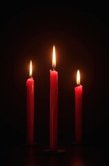 Velas rojas sobre fondo oscuro.