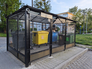 Closed metal site for storing large plastic waste containers for separate waste in one of the city districts in Poland