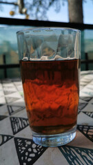 glass of iced tea on a terrace with trees in the background