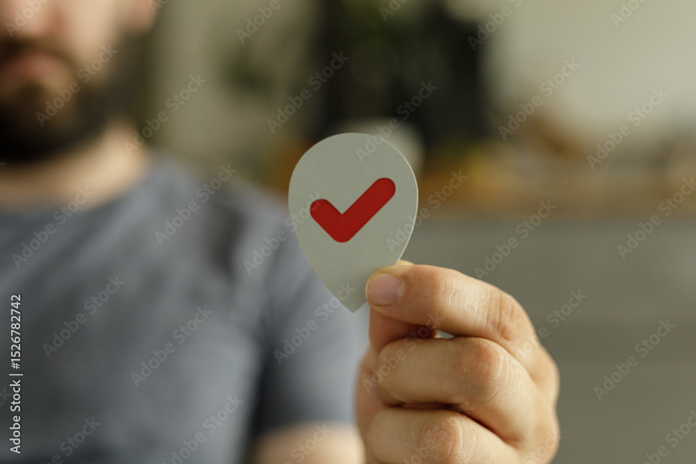 Poster Close-up of a man's hand holding a location marker with a check mark, signifying completion or success.