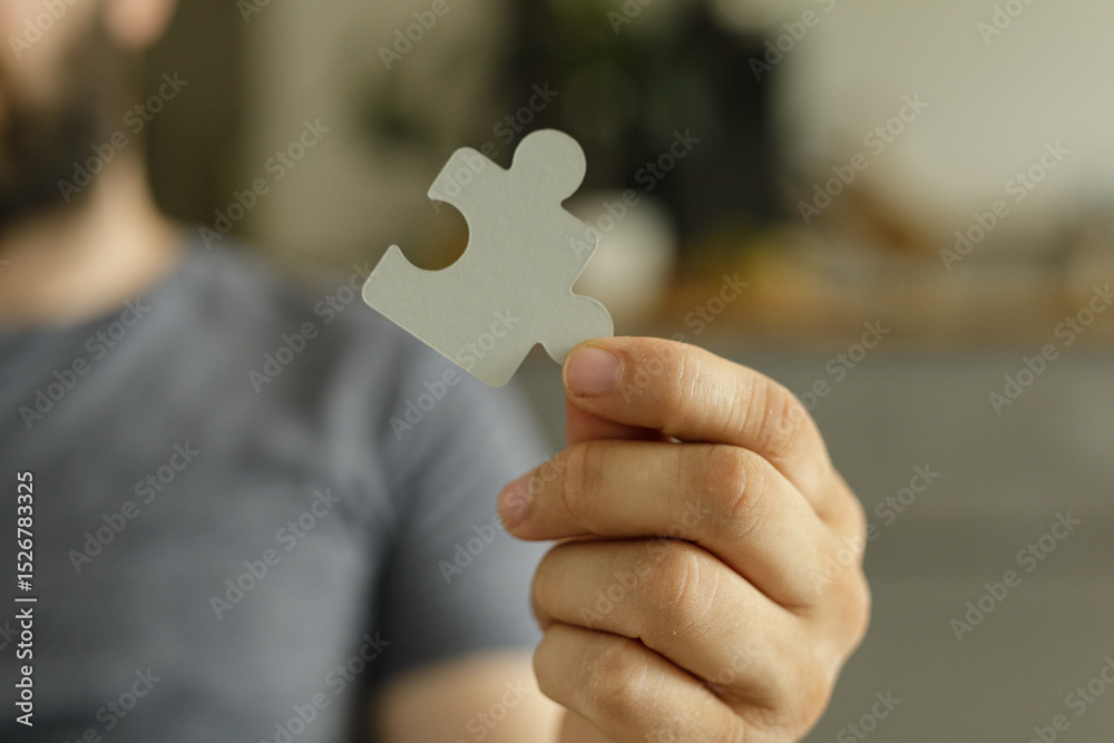 Poster close-up of a person's hand holding a puzzle piece. represents solutions, teamwork, and problem-solv