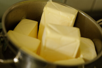 High-quality image of fresh butter chunks in a metal bowl. Perfect for food blogs, culinary...