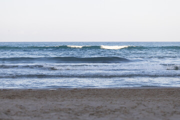 Beach landscape at sunset with waves.