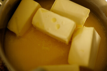 Close-up of butter cubes melting in a saucepan. Perfect for recipes and cooking blogs.