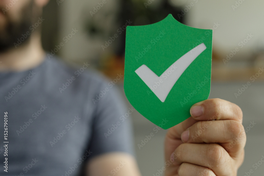 Poster image of a person holding a green shield with a checkmark, symbolizing security and approval.