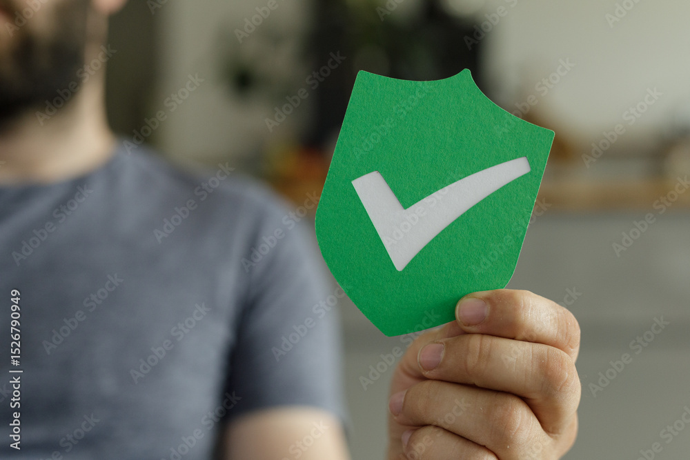 Poster image of a hand holding a green shield with a white checkmark, symbolizing security and approval.